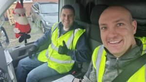 2 men in a van collecting Christmas tress for charity donations