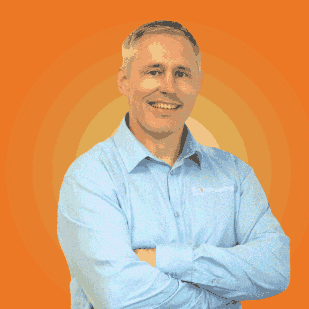 Smiling man in a light blue shirt with text on it, arms crossed. Bright orange background with a glowing effect.