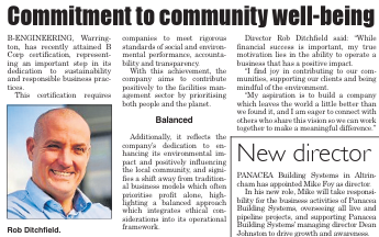 A close up image of a bald man in a blue shirt smiling for hte camera.