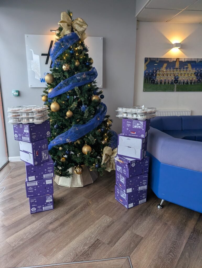 A Christmas tree with a pile of selection boxes on each side