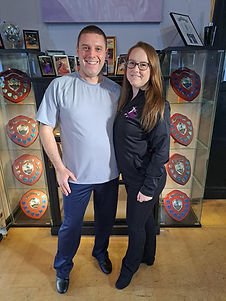 A couple stand in front of dance trophies