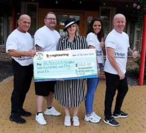 B-engineering donates towards a charitable cause- a group of 5 hold a large cheque