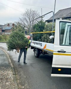 Man carrying Christmas tree to van