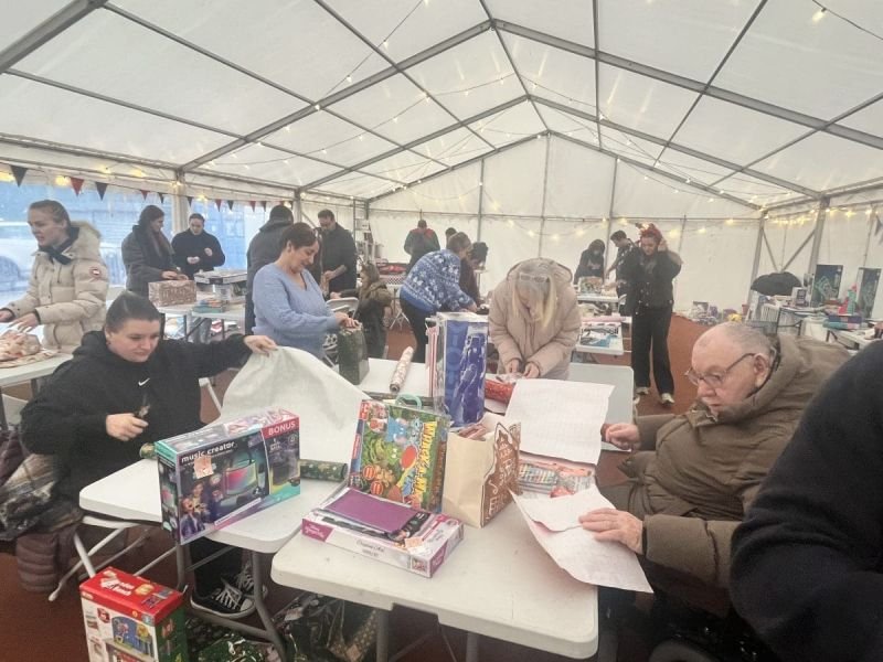a marquee filled with people wrapping gifts